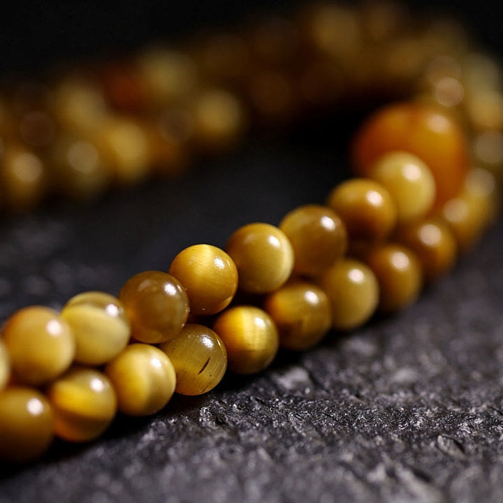 Bracelet à pompon de protection Dorje en cuivre avec 108 Buddha Stones Mala en œil de tigre naturel