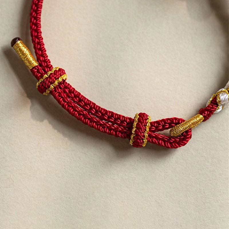 Bracelet porte-bonheur en corde avec breloque en fleur de pêcher et nœud d'amour véritable fait à la main par Buddha Stones