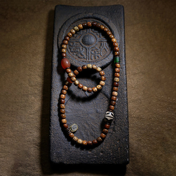 Bracelet triple tour en perles d'ambre et dzi tibétaines en Buddha Stones et graines de Bodhi, perles d'agate et de déesse de la richesse Zakiram