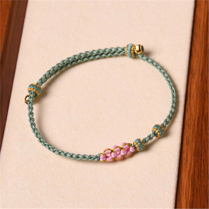 Bracelet tressé en corde de protection en fleur de pêcher fait main par Buddha Stones