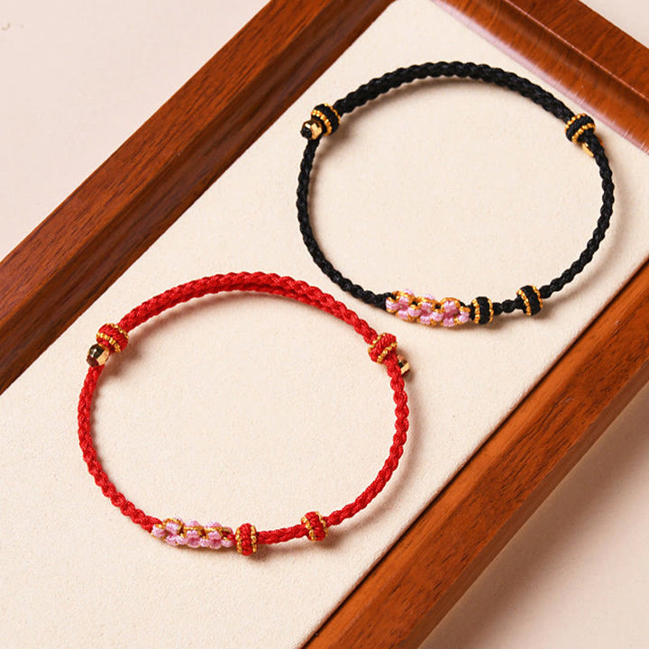 Bracelet tressé en corde de protection en fleur de pêcher fait main par Buddha Stones