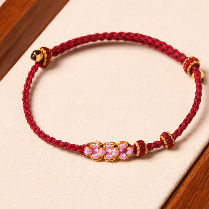 Bracelet tressé en corde de protection en fleur de pêcher fait main par Buddha Stones