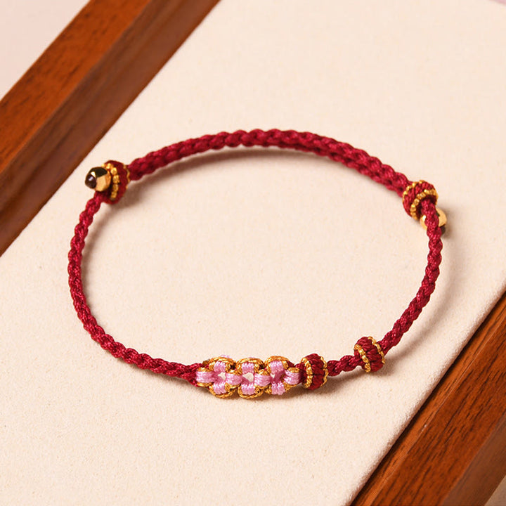 Bracelet tressé en corde de protection en fleur de pêcher fait main par Buddha Stones