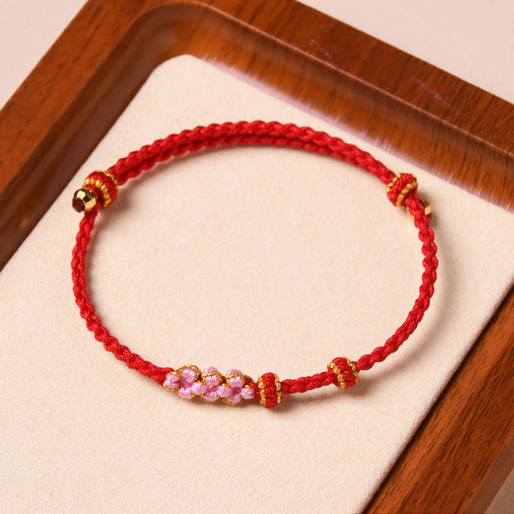 Bracelet tressé en corde de protection en fleur de pêcher fait main par Buddha Stones