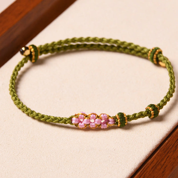 Bracelet tressé en corde de protection en fleur de pêcher fait main par Buddha Stones