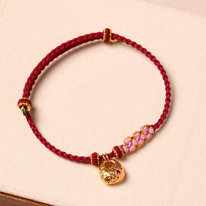 Bracelet tressé en corde de protection en fleur de pêcher fait main par Buddha Stones