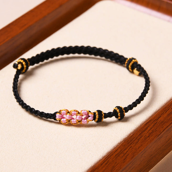 Bracelet tressé en corde de protection en fleur de pêcher fait main par Buddha Stones