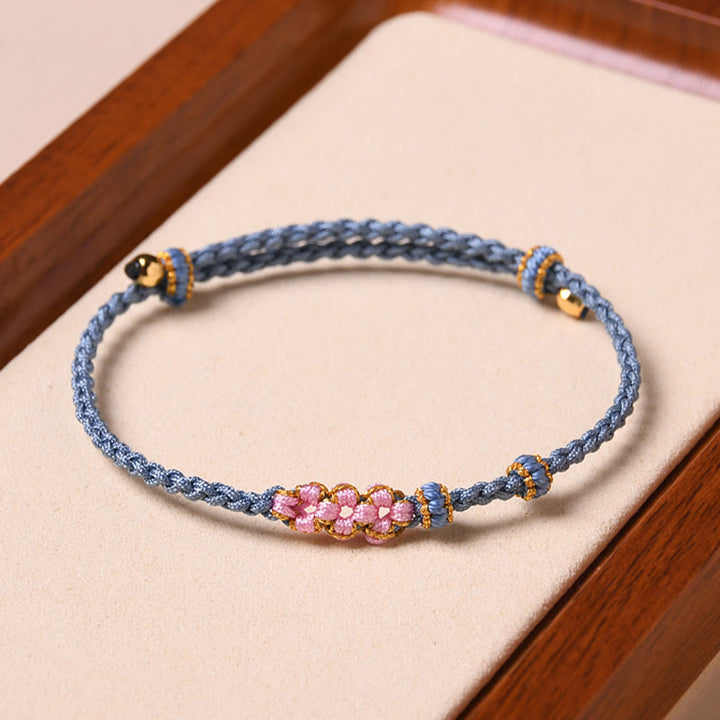 Bracelet tressé en corde de protection en fleur de pêcher fait main par Buddha Stones