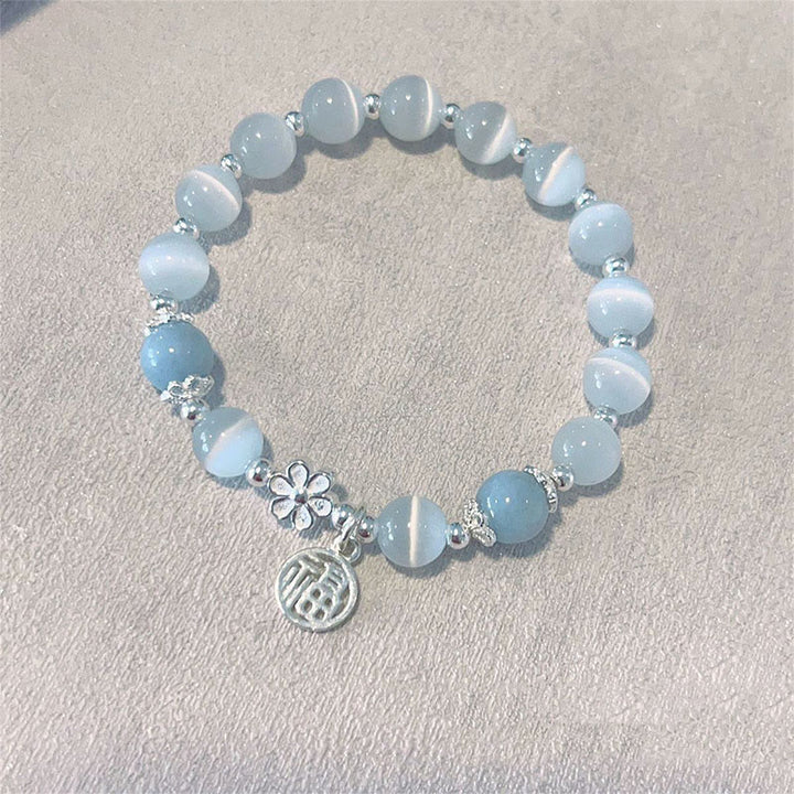 Bracelet de soutien à breloques en forme de Buddha Stones et de personnage Fu en cristal œil de chat et fleur de pêcher