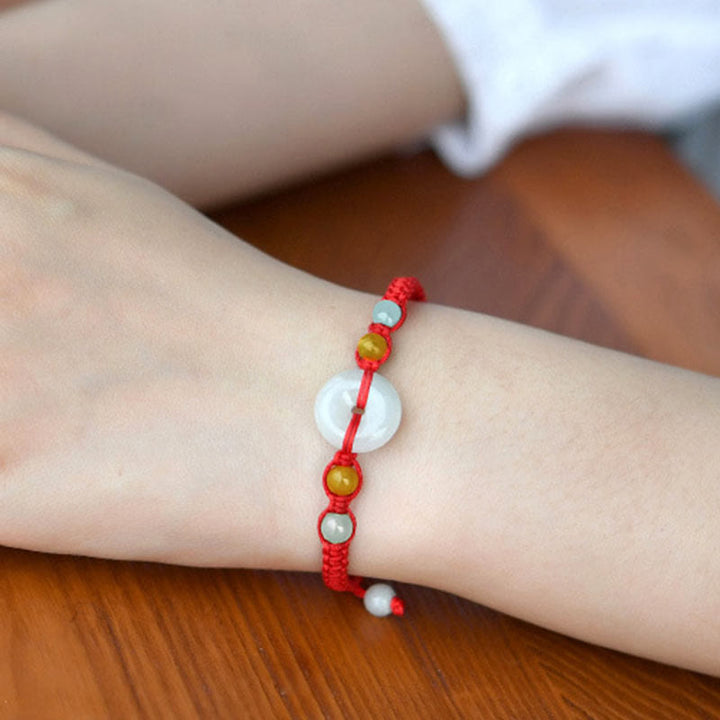 Bracelet en fil rouge avec boucle de paix en jade et Buddha Stones