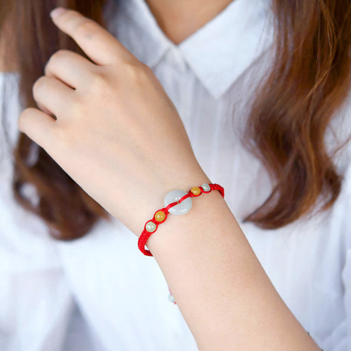 Bracelet en fil rouge avec boucle de paix en jade et Buddha Stones