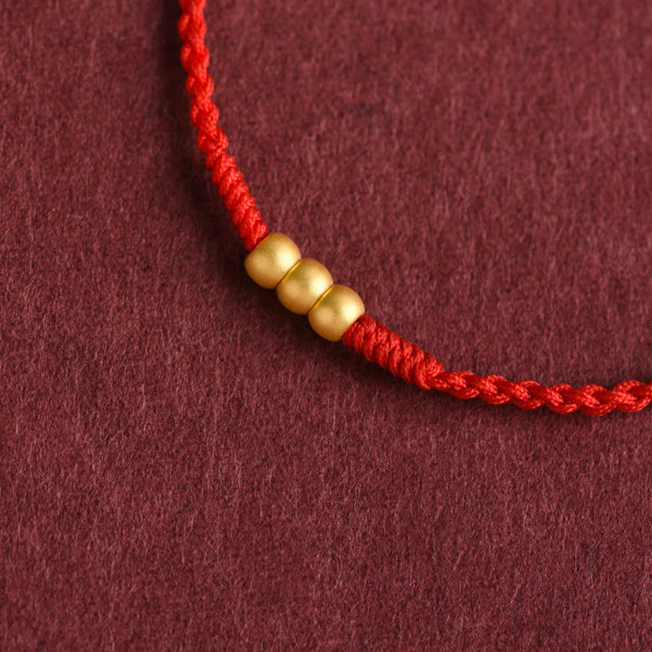 Bracelet de cheville en corde porte-bonheur fait main avec mini trois perles en or 999 de Buddha Stones - image 1