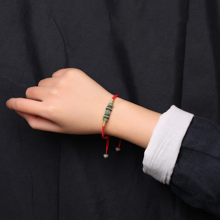 Bracelet en corde rouge avec perles de boulier en jade et Buddha Stones