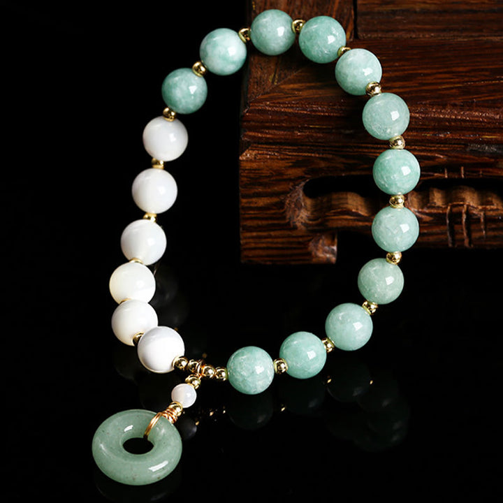 Bracelet d'abondance avec breloque en forme de boucle de paix , Buddha Stones , jade, trochus, fer à cheval, escargot