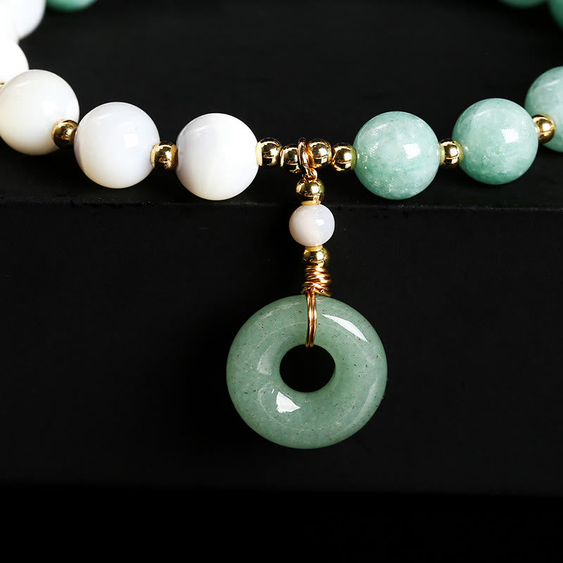 Bracelet d'abondance avec breloque en forme de boucle de paix , Buddha Stones , jade, trochus, fer à cheval, escargot