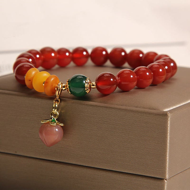 Bracelet d'acceptation de soi avec breloque pêche et agate rouge de Buddha Stones