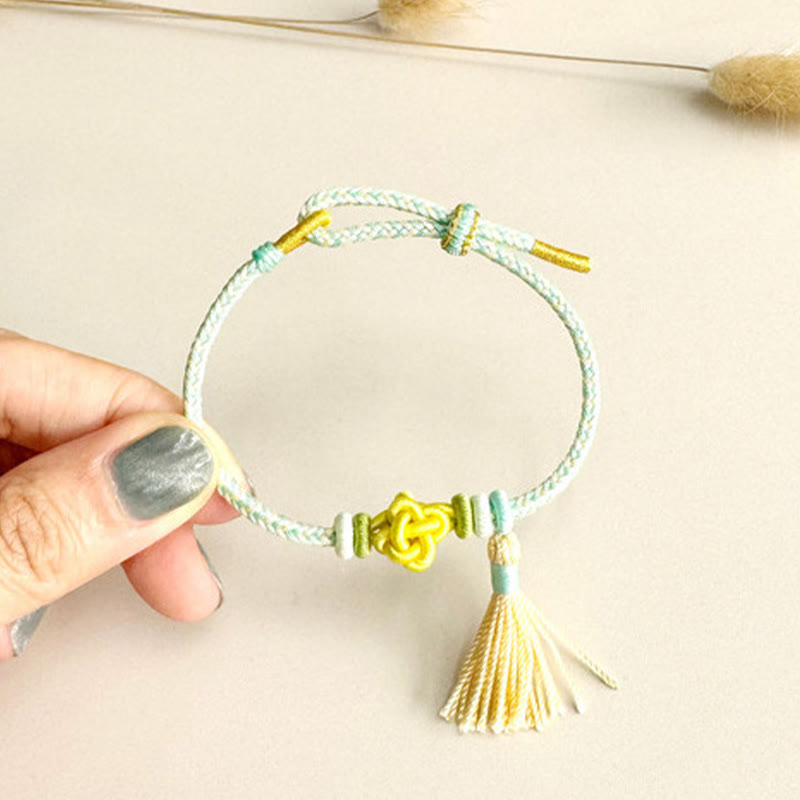 Bracelet de protection avec pompons et nœuds en fleurs de pêcher et Buddha Stones colorées