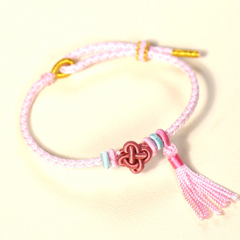 Bracelet de protection avec pompons et nœuds en fleurs de pêcher et Buddha Stones colorées