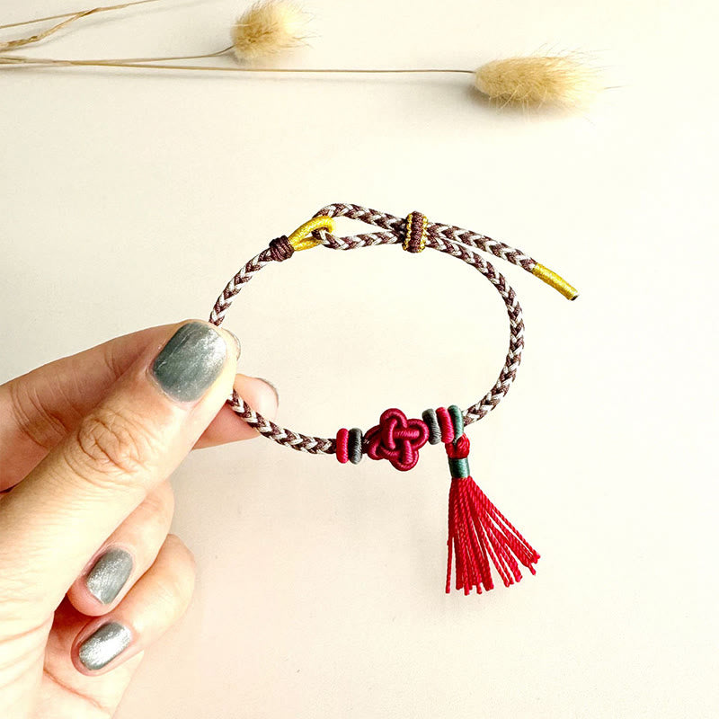 Bracelet de protection avec pompons et nœuds en fleurs de pêcher et Buddha Stones colorées