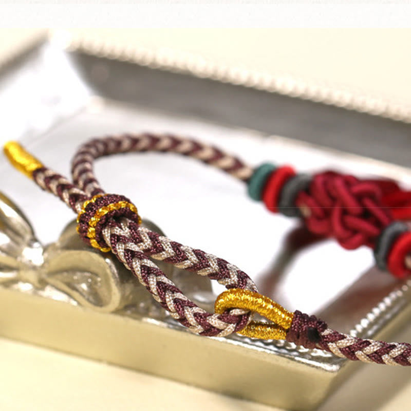 Bracelet de protection avec pompons et nœuds en fleurs de pêcher et Buddha Stones colorées