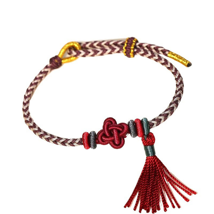 Bracelet de protection avec pompons et nœuds en fleurs de pêcher et Buddha Stones colorées