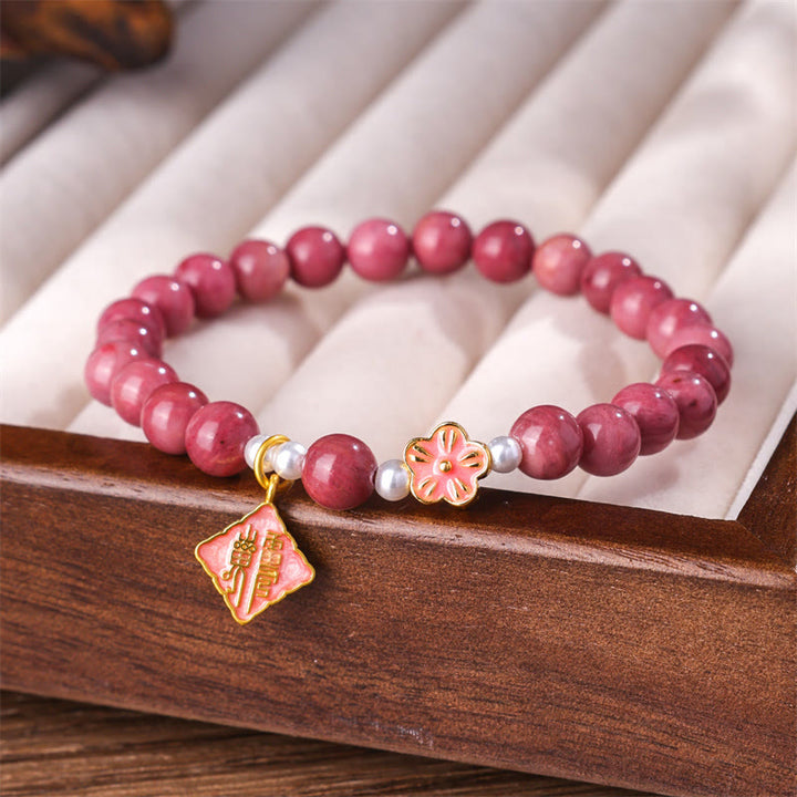 Bracelet d'énergie aimante en rhodonite et fleur de pêcher de Buddha Stones