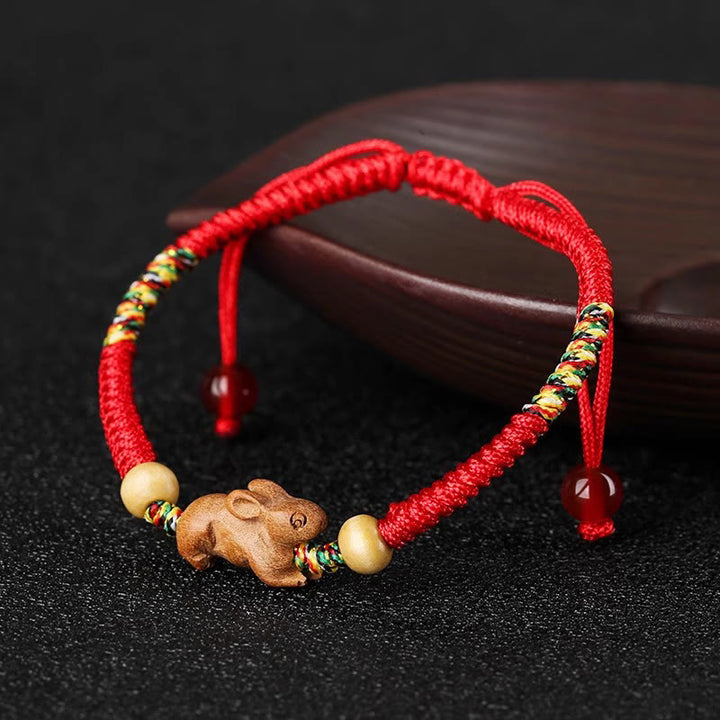 Bracelet porte-bonheur en bois de pêcher avec cordon rouge et signe du zodiaque chinois fait main par Buddha Stones