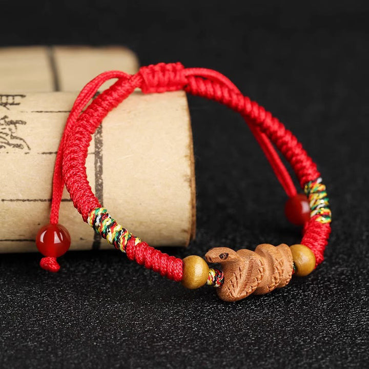Bracelet porte-bonheur en bois de pêcher avec cordon rouge et signe du zodiaque chinois fait main par Buddha Stones