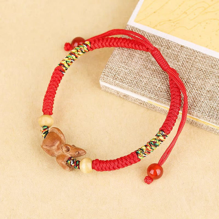 Bracelet porte-bonheur en bois de pêcher avec cordon rouge et signe du zodiaque chinois fait main par Buddha Stones