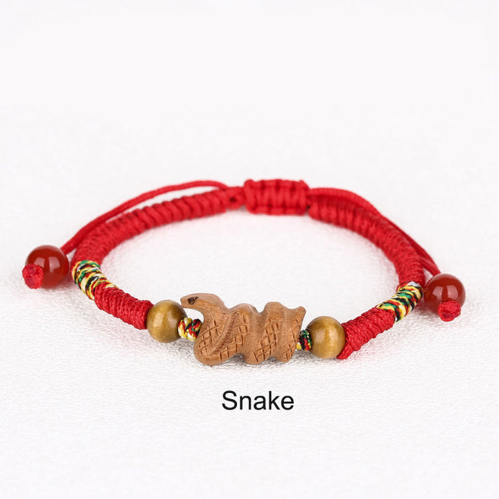 Bracelet porte-bonheur en bois de pêcher avec cordon rouge et signe du zodiaque chinois fait main par Buddha Stones