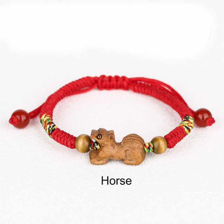 Bracelet porte-bonheur en bois de pêcher avec cordon rouge et signe du zodiaque chinois fait main par Buddha Stones