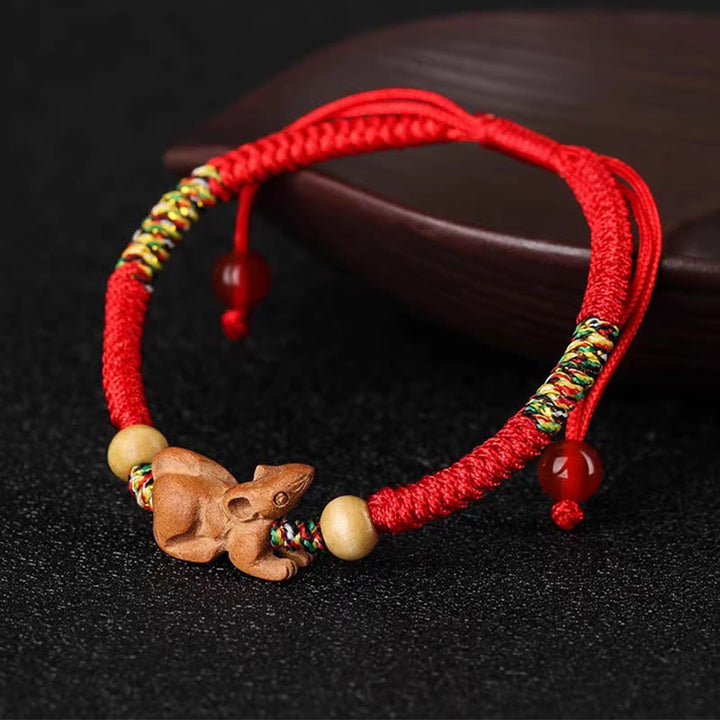 Bracelet porte-bonheur en bois de pêcher avec cordon rouge et signe du zodiaque chinois fait main par Buddha Stones