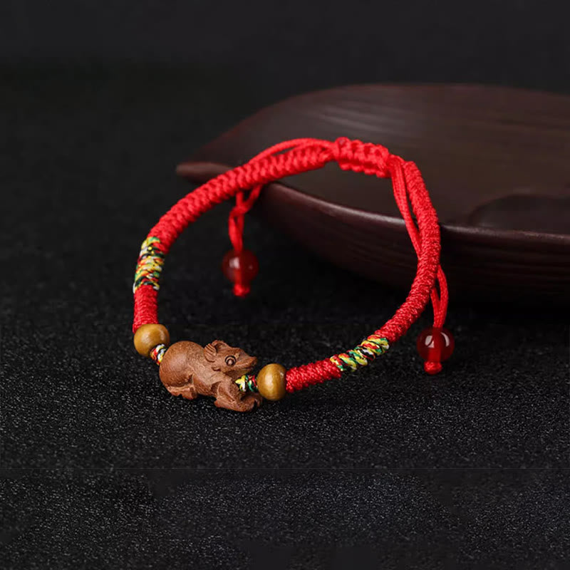 Bracelet porte-bonheur en bois de pêcher avec cordon rouge et signe du zodiaque chinois fait main par Buddha Stones