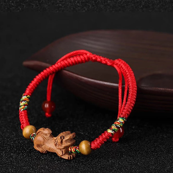 Bracelet porte-bonheur en bois de pêcher avec cordon rouge et signe du zodiaque chinois fait main par Buddha Stones