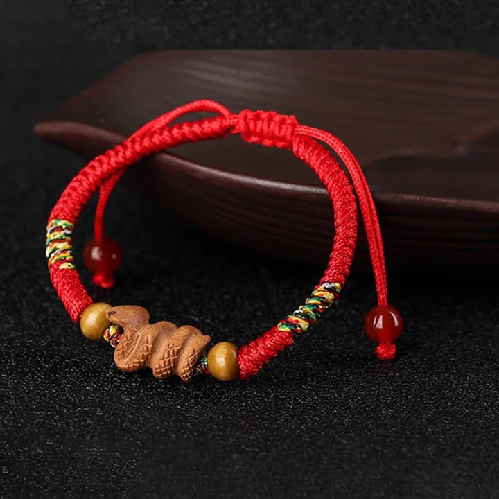 Bracelet porte-bonheur en bois de pêcher avec cordon rouge et signe du zodiaque chinois fait main par Buddha Stones