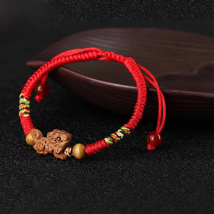Bracelet porte-bonheur en bois de pêcher avec cordon rouge et signe du zodiaque chinois fait main par Buddha Stones