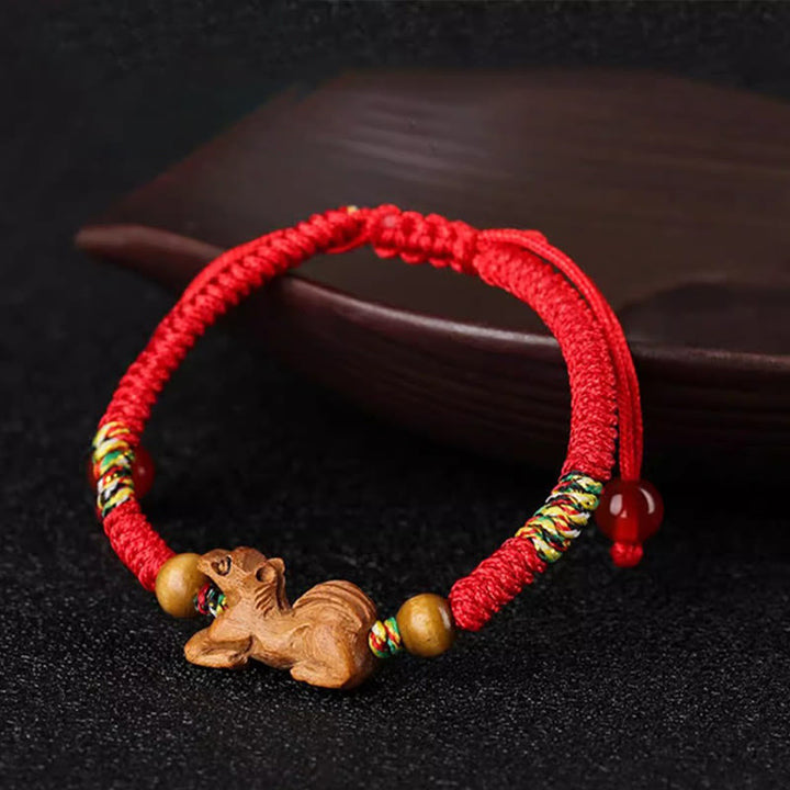 Bracelet porte-bonheur en bois de pêcher avec cordon rouge et signe du zodiaque chinois fait main par Buddha Stones