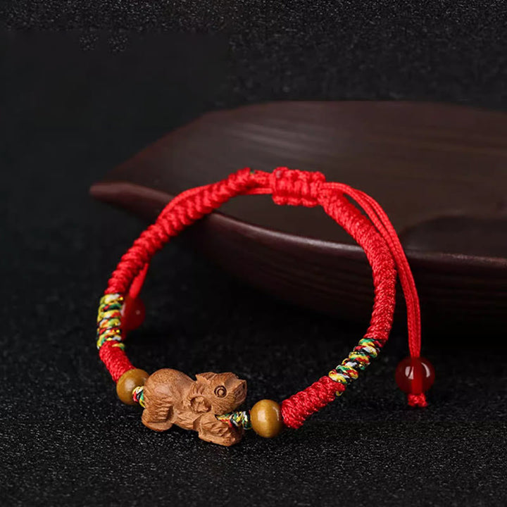 Bracelet porte-bonheur en bois de pêcher avec cordon rouge et signe du zodiaque chinois fait main par Buddha Stones