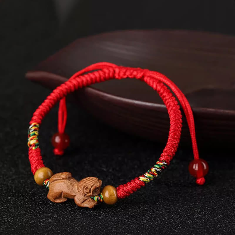 Bracelet porte-bonheur en bois de pêcher avec cordon rouge et signe du zodiaque chinois fait main par Buddha Stones