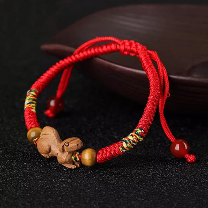 Bracelet porte-bonheur en bois de pêcher avec cordon rouge et signe du zodiaque chinois fait main par Buddha Stones