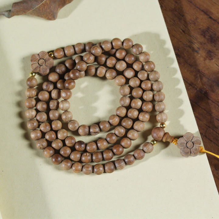 Bracelet Mala de guérison avec breloque en bois de santal et fleur de prunier et Buddha Stones