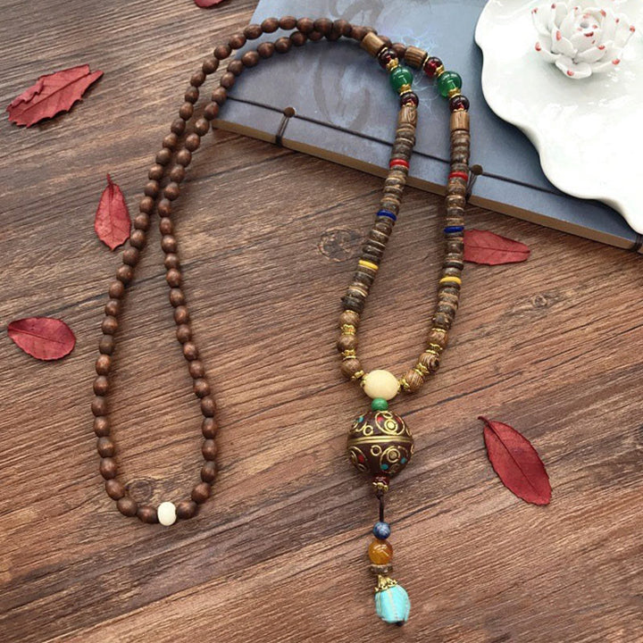 Buddha Stones pendentif en perles de cuivre et mantra lumineux en bois de schima, fait à la main en coquille de noix de coco tibétaine