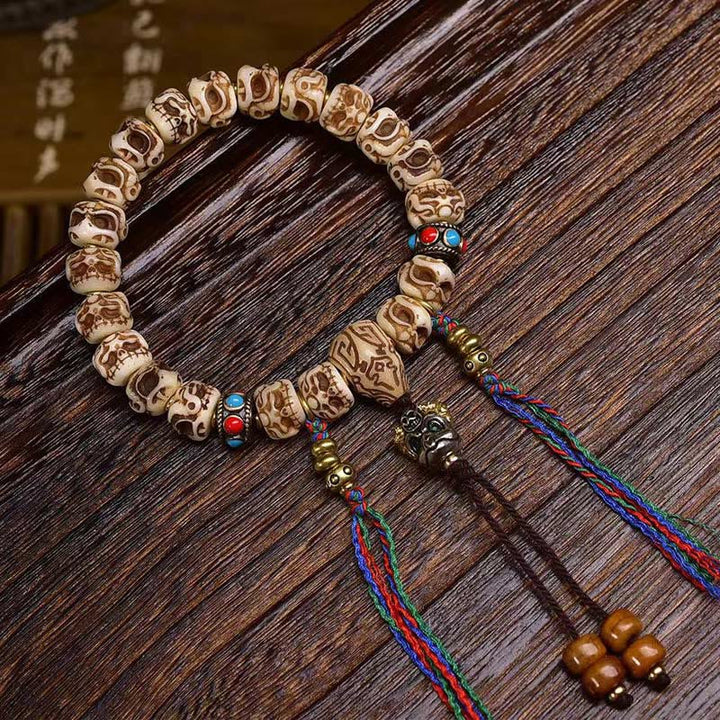 Bracelet tibétain à pompon sculpté en Buddha Stones