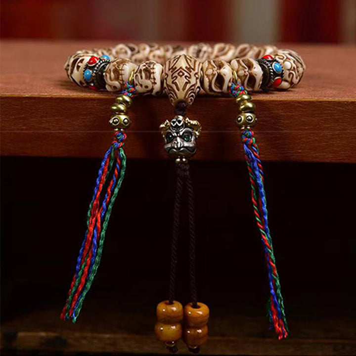 Bracelet tibétain à pompon sculpté en Buddha Stones