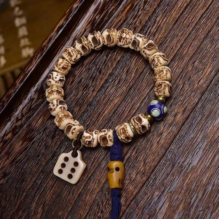 Bracelet tibétain à pompon sculpté en Buddha Stones