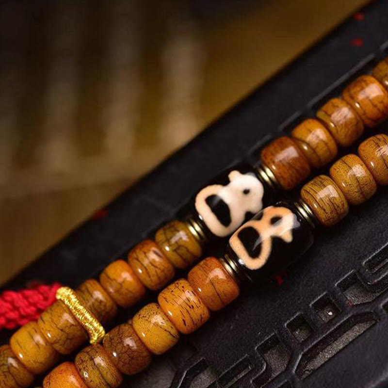 Mala tibétain à 108 perles en os de chameau et pompon porte-bonheur en Buddha Stones