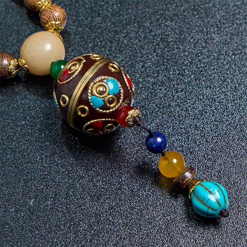 Buddha Stones pendentif en perles de cuivre et mantra lumineux en bois de schima, fait à la main en coquille de noix de coco tibétaine