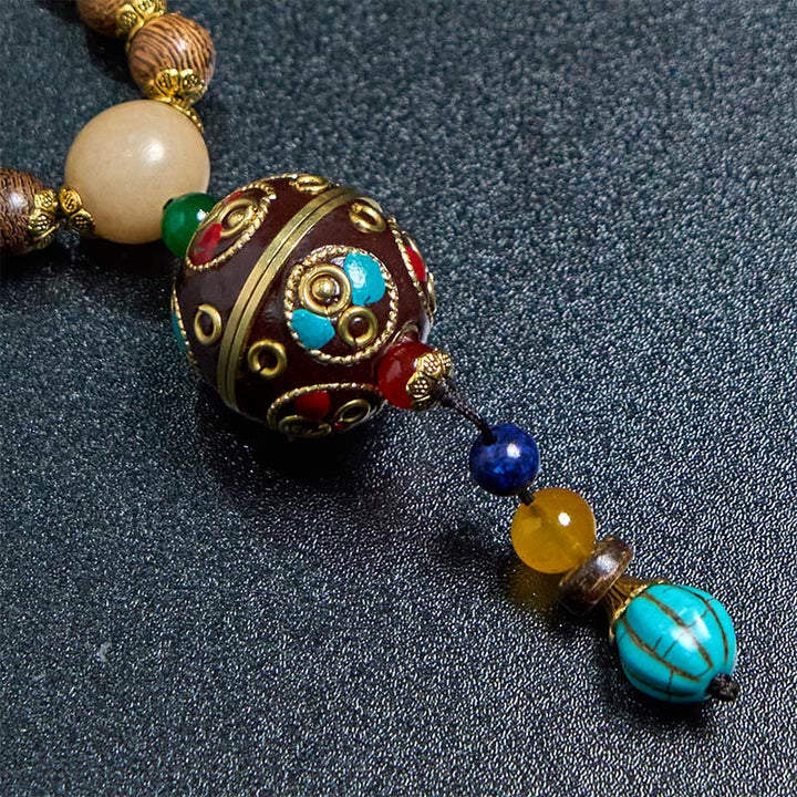 Buddha Stones pendentif en perles de cuivre et mantra lumineux en bois de schima, fait à la main en coquille de noix de coco tibétaine