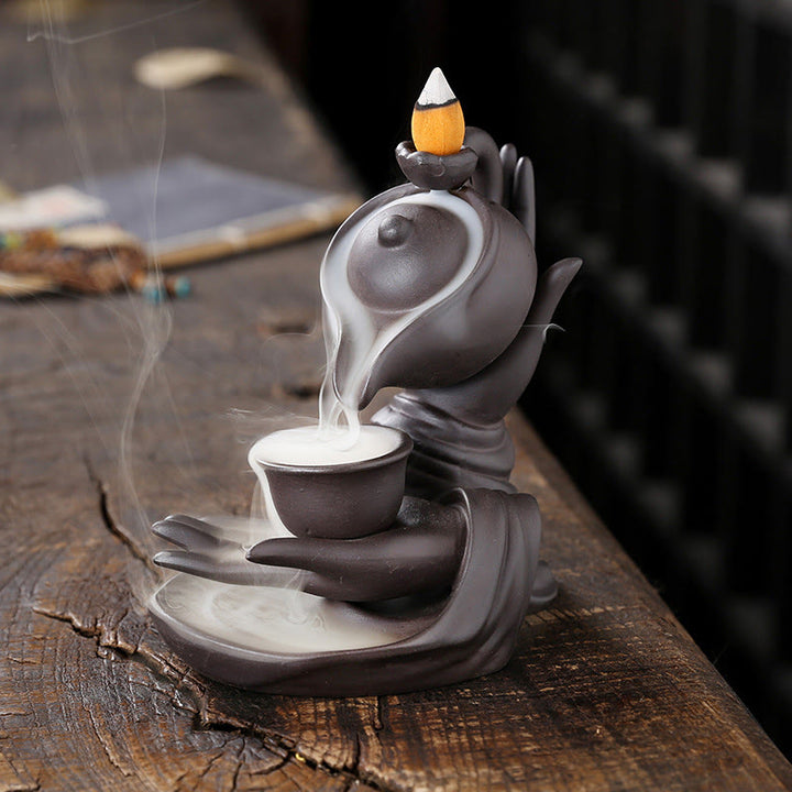 Buddha Stones Bouddha Main Tenant Théière Tasse Céramique Fontaine de Fumée à Refoulement Brûleur d'Encens de Guérison Décoration - Marron Noir 13,7*9*13,9 cm - image 1