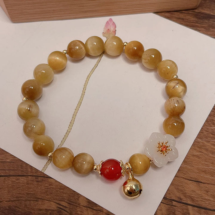 Bracelet courage en forme de clochette et œil de tigre doré naturel Buddha Stones - Œil de tigre et fleur blanche (tour de poignet : 14-16 cm) - image 0